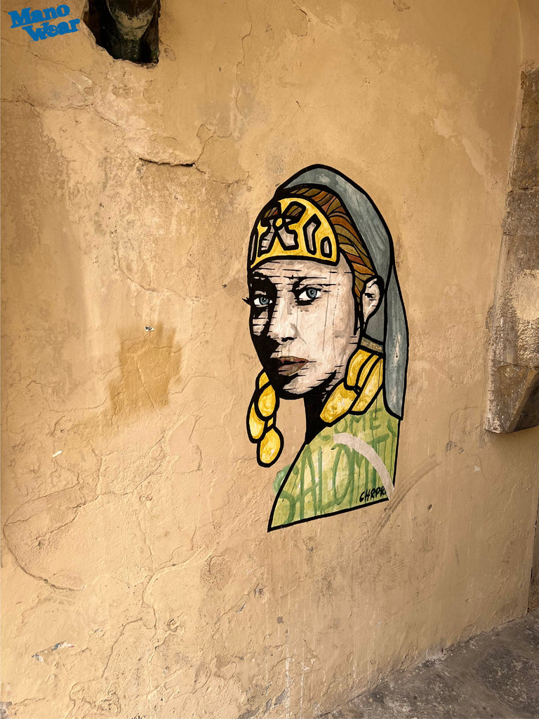 Graffiti showing a female head on beige wall in Firenze