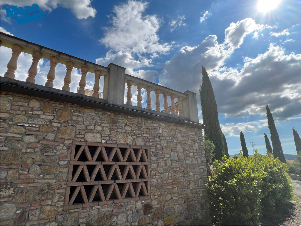 View of wall and balustrade of swimming pool and sky with sun and clouds