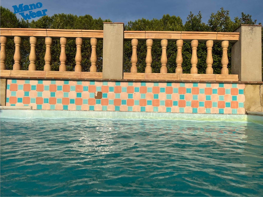 Water of a swimming pool with balustrade and tiles in the background